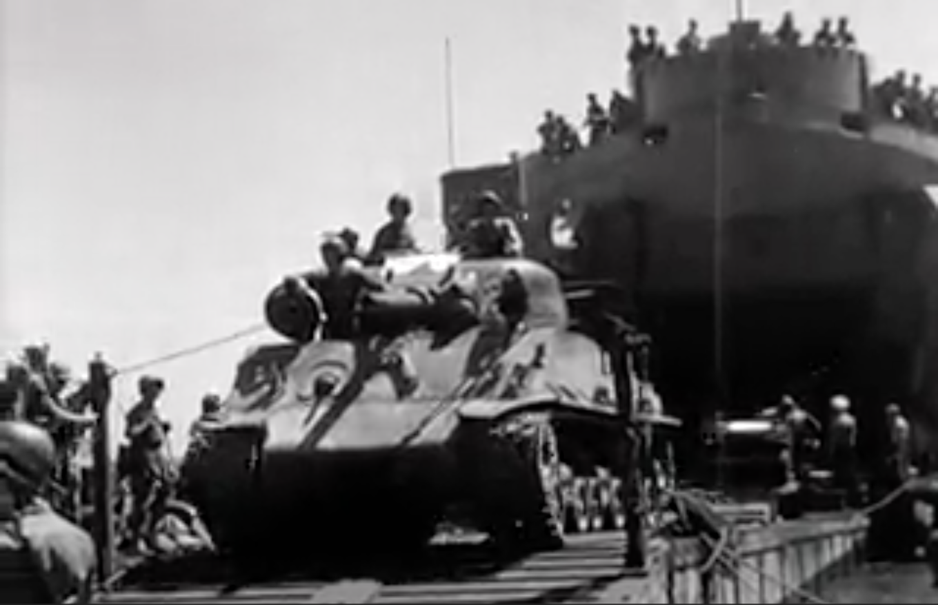 Zwart-wit beeld van een Sherman tank met Nederlandse militairen wordt vanuit het schip aan wal gereden ten tijden de eerste 'politionele actie'