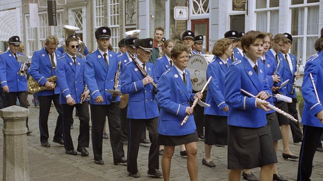 Foto van de Palmpasenoptocht die wordt begeleid door de harmonie