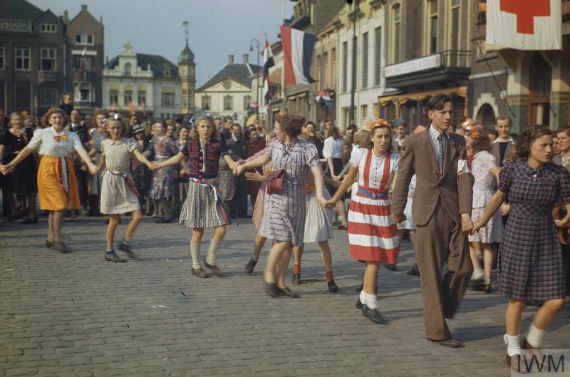 Foto van mensen die hand in hand door de straat gaan ten tijden van de bevrijding in 1945